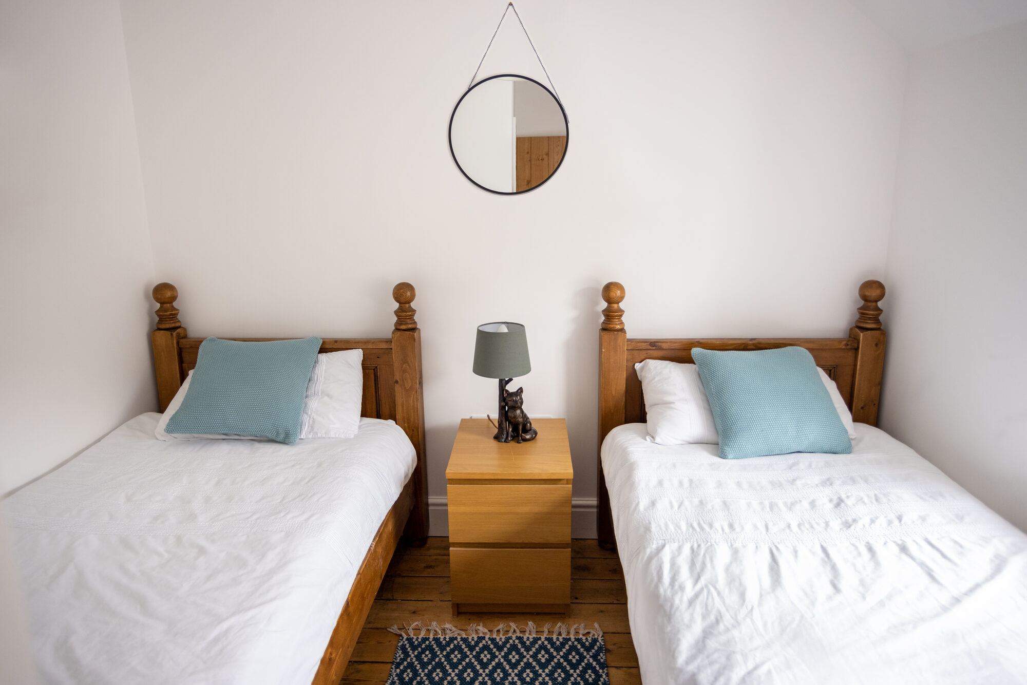 Twin bedroom with pine beds and mirror