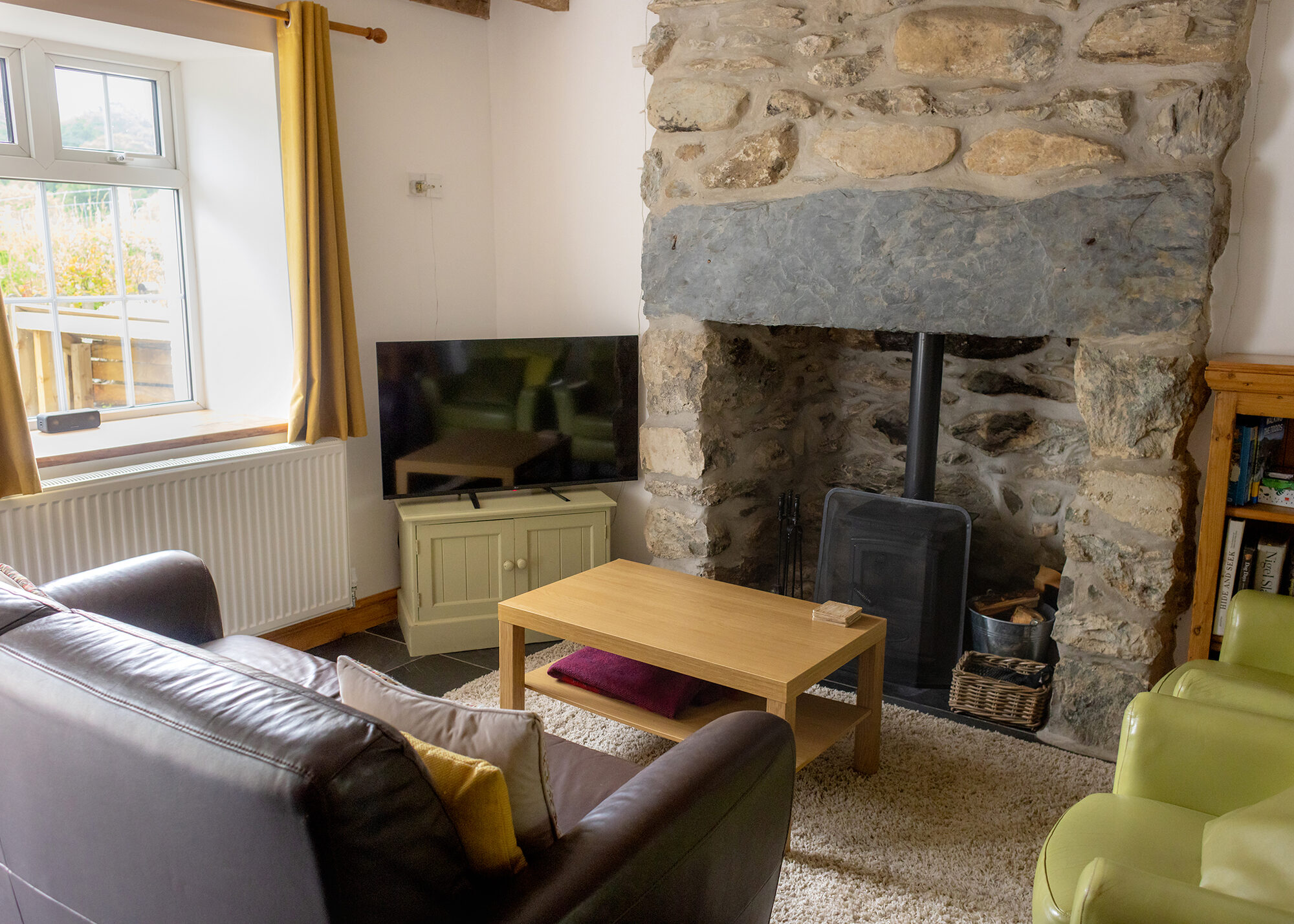 Lounge with log burner set into stone fireplace